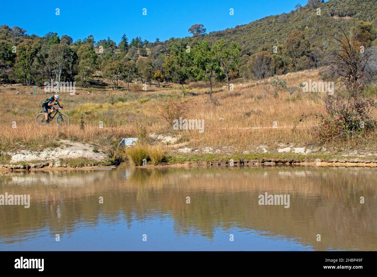 Mountainbiken an einem See vorbei auf dem Brindabella Trail bei Stromlo Stockfoto