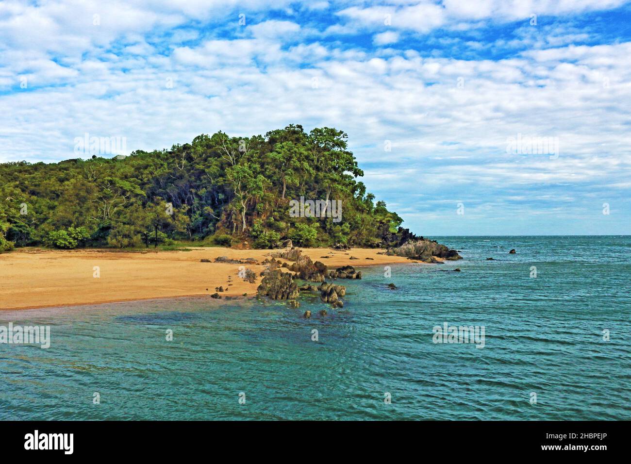 Palm Cove Beach im äußersten Norden im Frühsommer - am nördlichen Ende, vom Steg aus - Blick über das Wasser auf die Felsaufschlüsse und die Landzunge Stockfoto