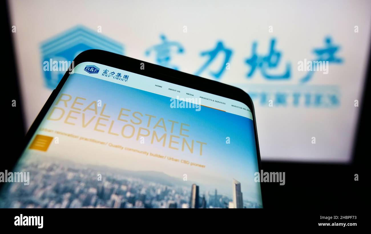 Smartphone mit Logo des chinesischen Immobilienunternehmens Guangzhou RF Properties auf dem Bildschirm vor der Website. Konzentrieren Sie sich auf die obere linke Seite des Telefondisplays. Stockfoto