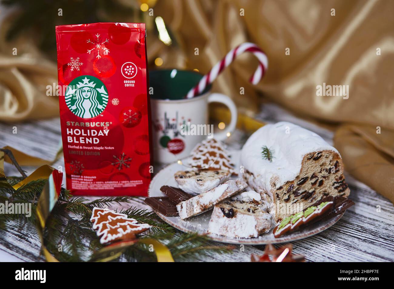 Kiew, Ukraine - 11. Dezember 2021: Ästhetischer starbucks-Kaffee in roter Festverpackung mit Tasse Bonbon-Kegel-Stick. Weihnachtsstollen, Kekse und Chocola Stockfoto