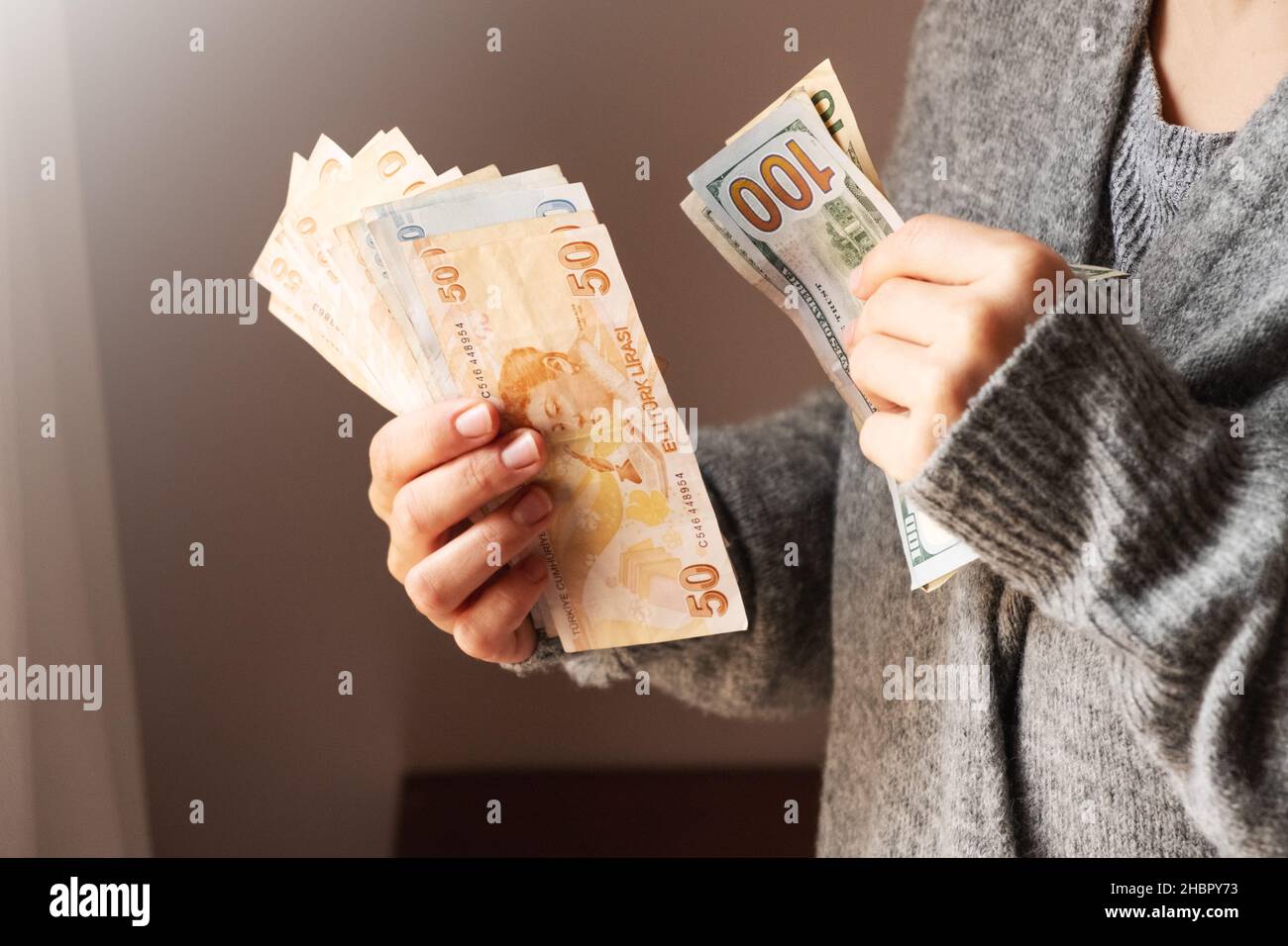 Türkische Lira- und Dollarnoten in Frauenhand. Die Papierwährung der Türkei. Die aktuellen türkischen Lira werden von der Zentralbank der Republik Türkei ausgegeben. Konzept der Finanzkrise. Stockfoto