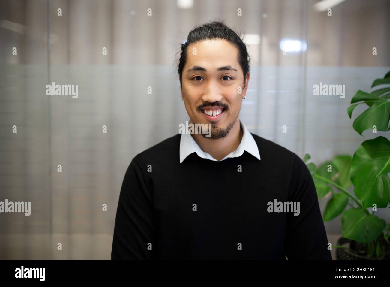 Lächelnder junger männlicher Profi im Büro Stockfoto