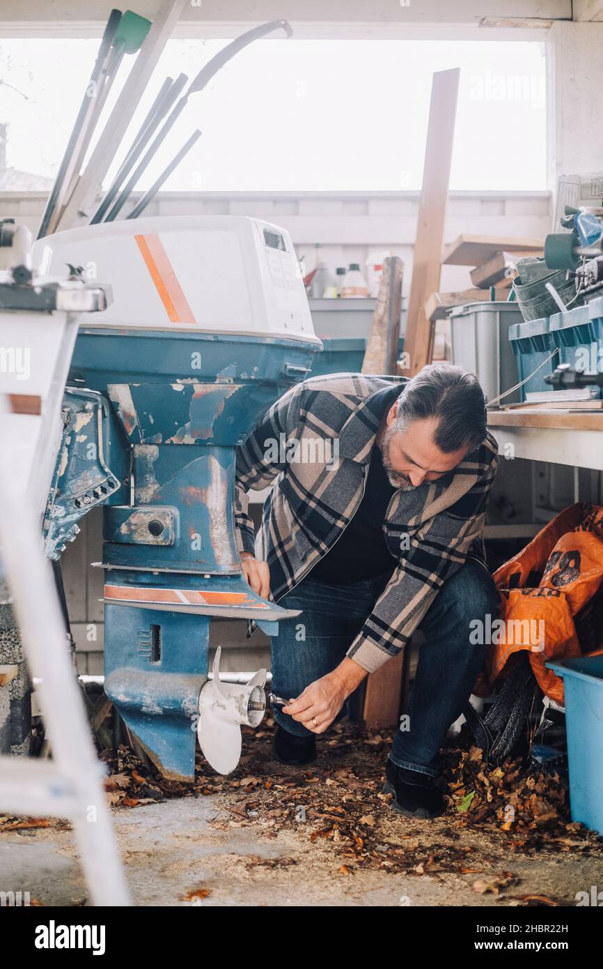 Reifer Mann repariert nautisches Schiff in der Garage Stockfoto