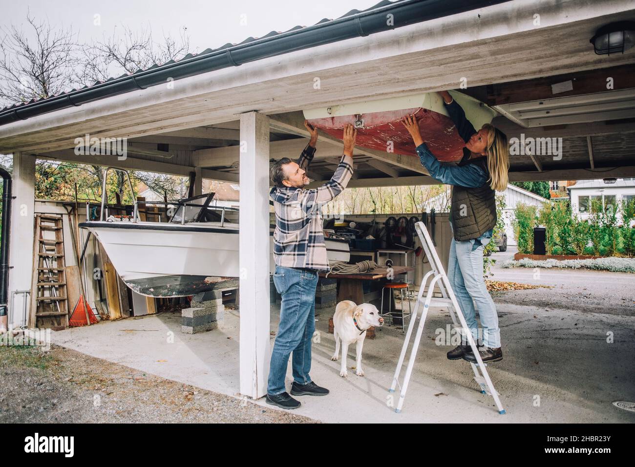 Heterosexuelles Paar, das nautisches Schiff in der Garage bindet Stockfoto