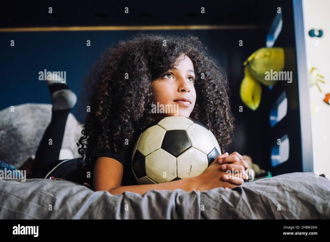 Mädchen mit Händen zusammengeklemmt Tag träumen im Schlafzimmer Stockfoto