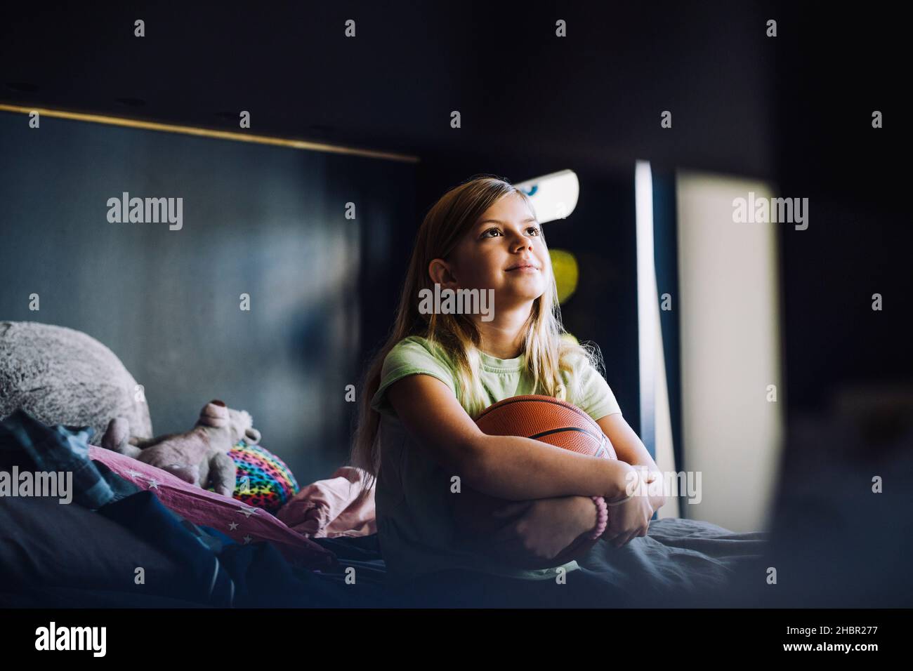 Kontemplatives Mädchen, das im Schlafzimmer sitzt Stockfoto