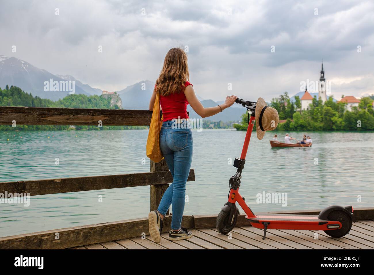 Weibliche Reisende mit Elektroroller als modernes ökologisches Transportmittel während der Erkundung des grünen Landes Slowenien im Urlaub. Grüne Öko-Energie Stockfoto