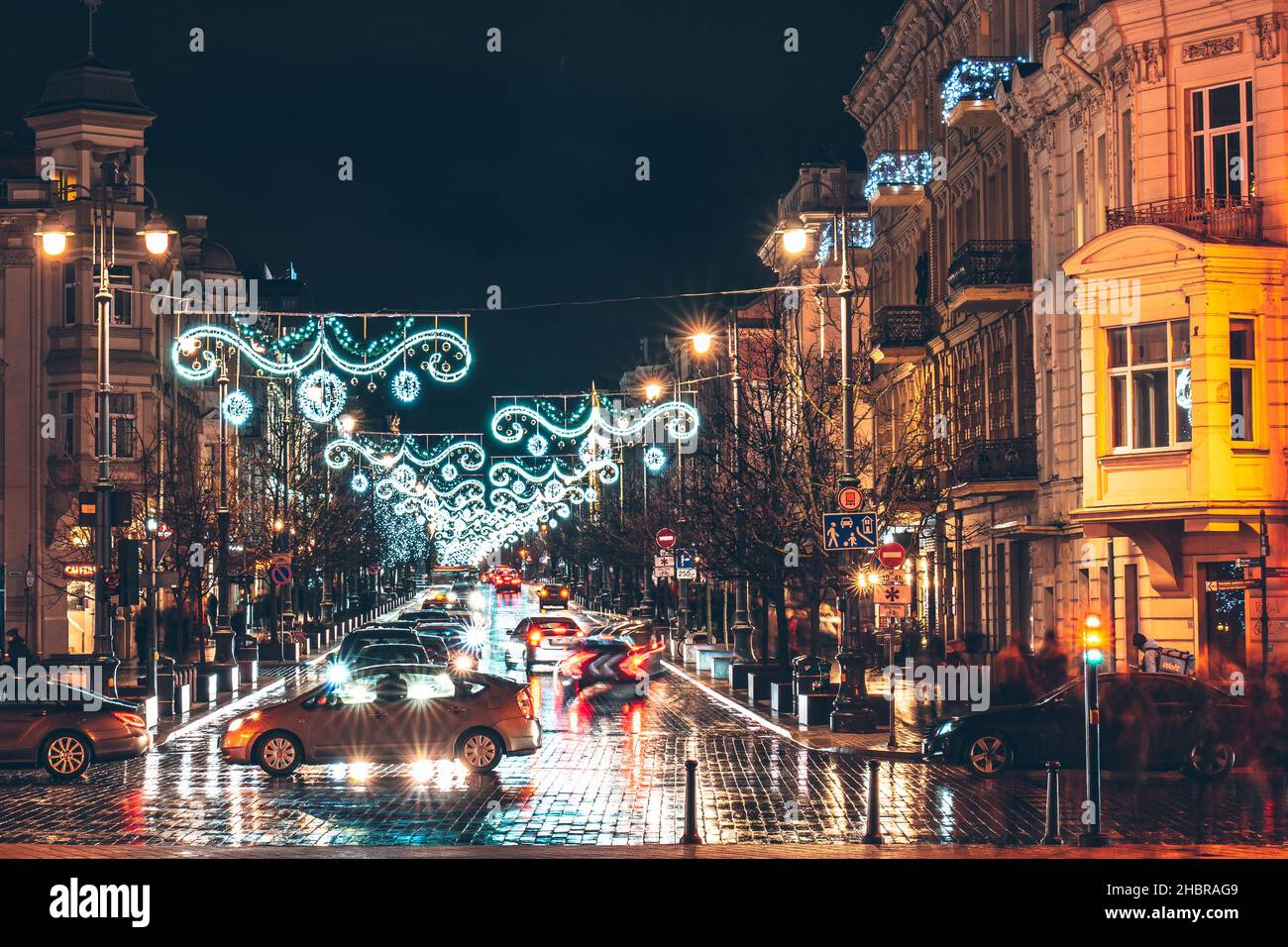 Vilnius, Litauen - 17th. Dezember 2021: Blick auf die Gediminas Avenue mit Weihnachtsschmuck und vorbeifahrenden Autos Stockfoto