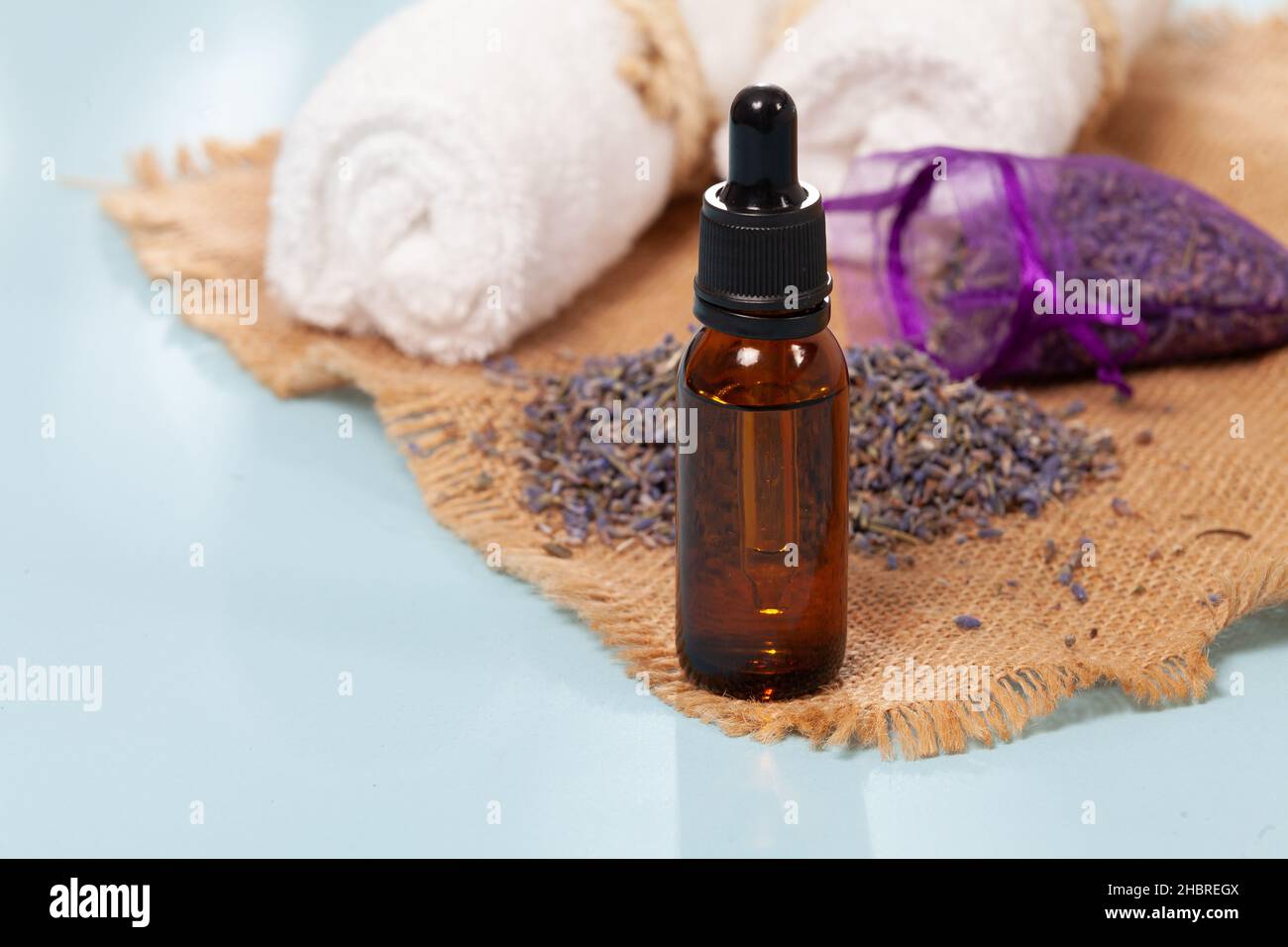 Lavandula - ätherisches Bio-Lavendel-Öl in Glasflasche mit getrockneten Blumen Stockfoto
