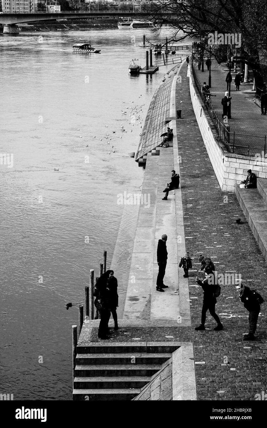 Zahlreiche Menschen genießen ihre Freizeit am Rheinufer in Basel. Stockfoto