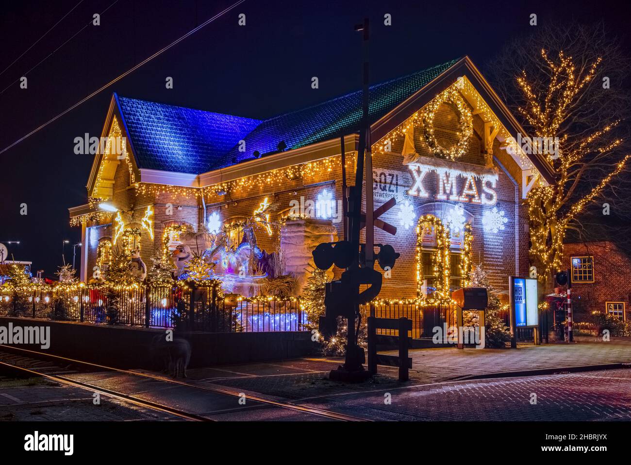 ARKEL, Niederlande, 18. DEZEMBER 2021 - der weihnachtsbahnhof mit vielen Dekorationsleuchten während der Weihnachtszeit mit einem großen WEIHNACHTSSCHILD, Stockfoto