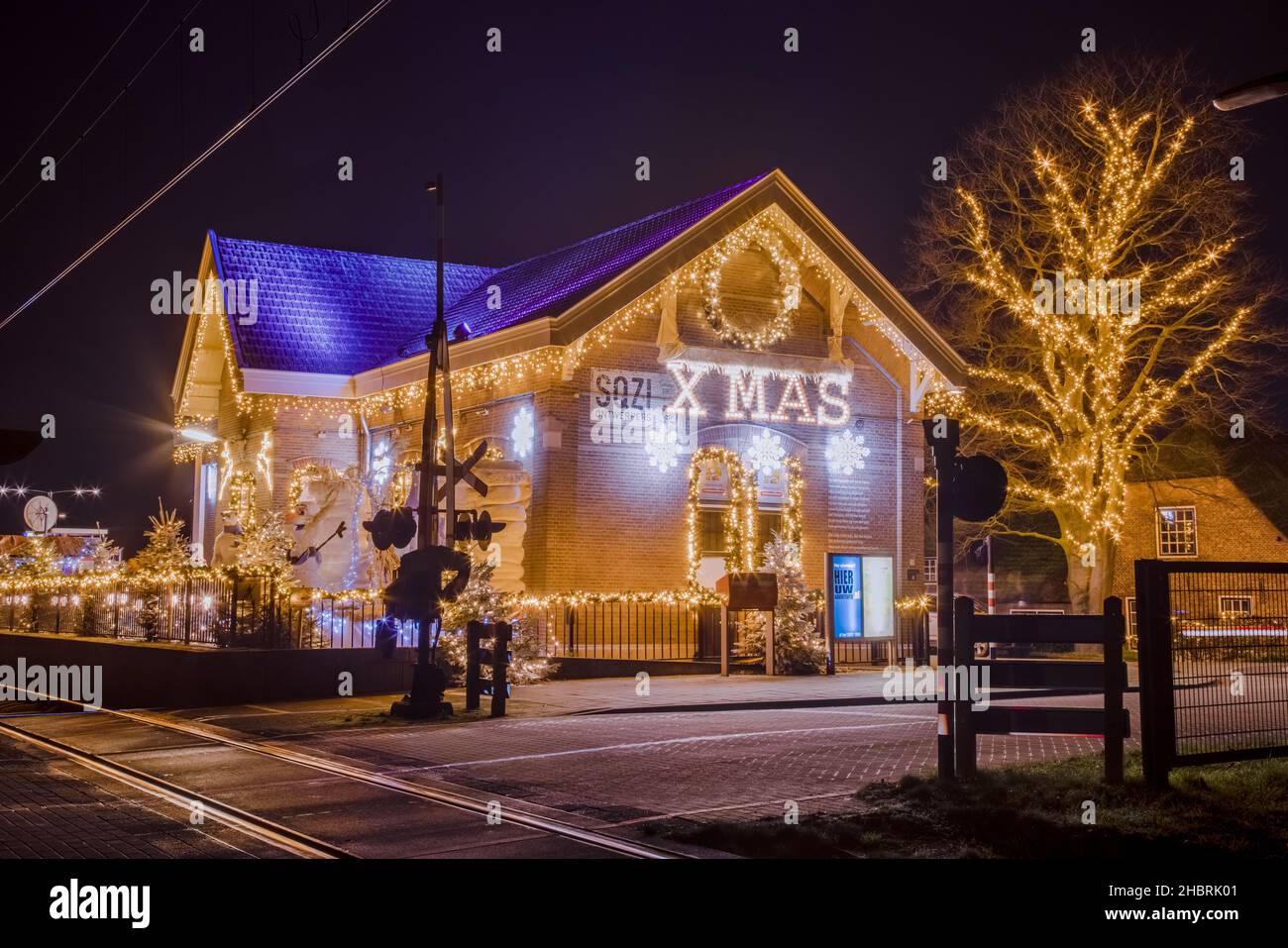 ARKEL, Niederlande, 18. DEZEMBER 2021 - der weihnachtsbahnhof mit vielen Dekorationsleuchten während der Weihnachtszeit mit einem großen WEIHNACHTSSCHILD, Stockfoto