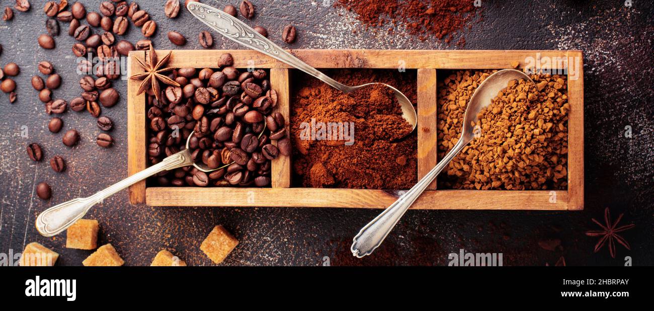 Food Hintergrund mit drei Arten von Kaffee: Bohnen, gemahlen, Instant in Holzkiste auf alten Beton braunen Hintergrund. Rustikaler Stil. Selektiver Fokus. Oben Stockfoto