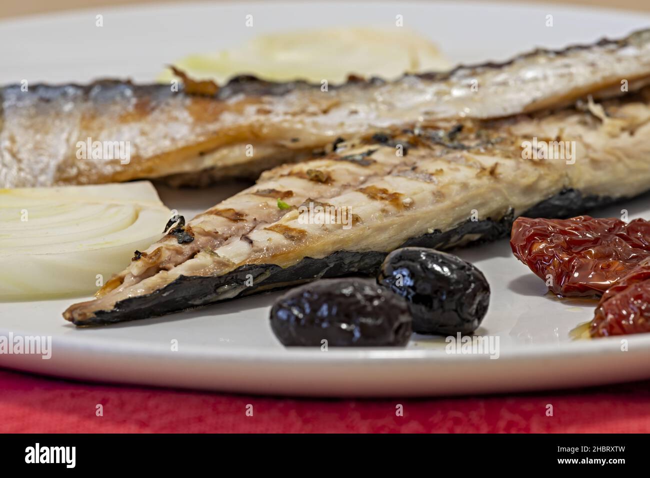 filetto di sgombro alla piastra con pomodoro secco olive nere finocchio Makro altra vista Stockfoto