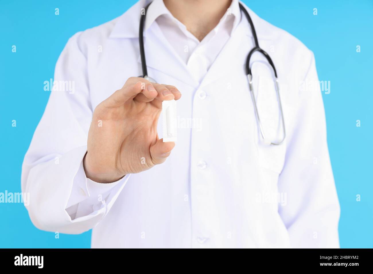 Arzt hält Zäpfchen auf blauem Hintergrund. Hämorrhoiden Konzept Stockfoto