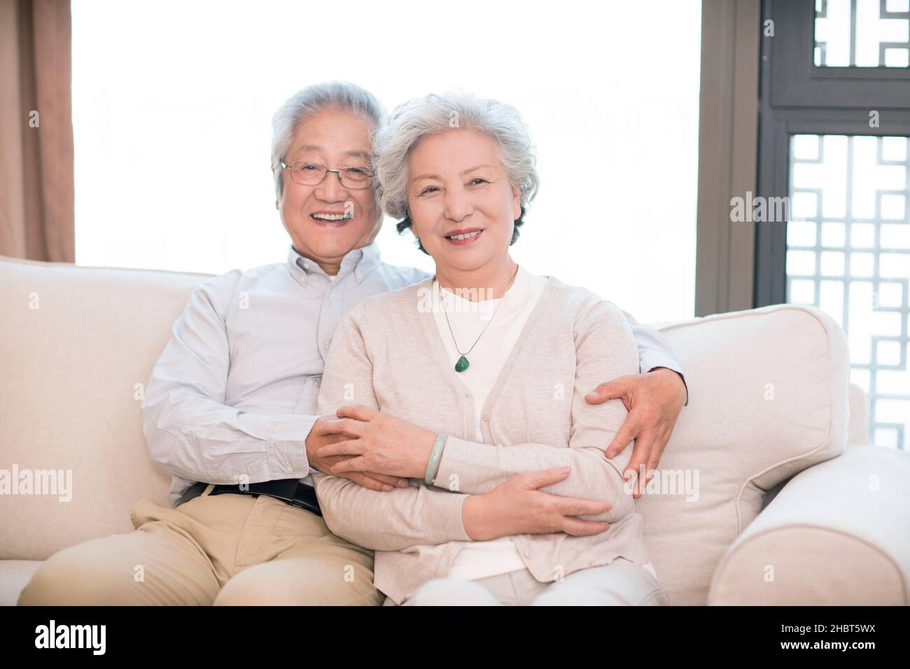Glückliches altes Paar, das auf dem Sofa sitzt Stockfoto