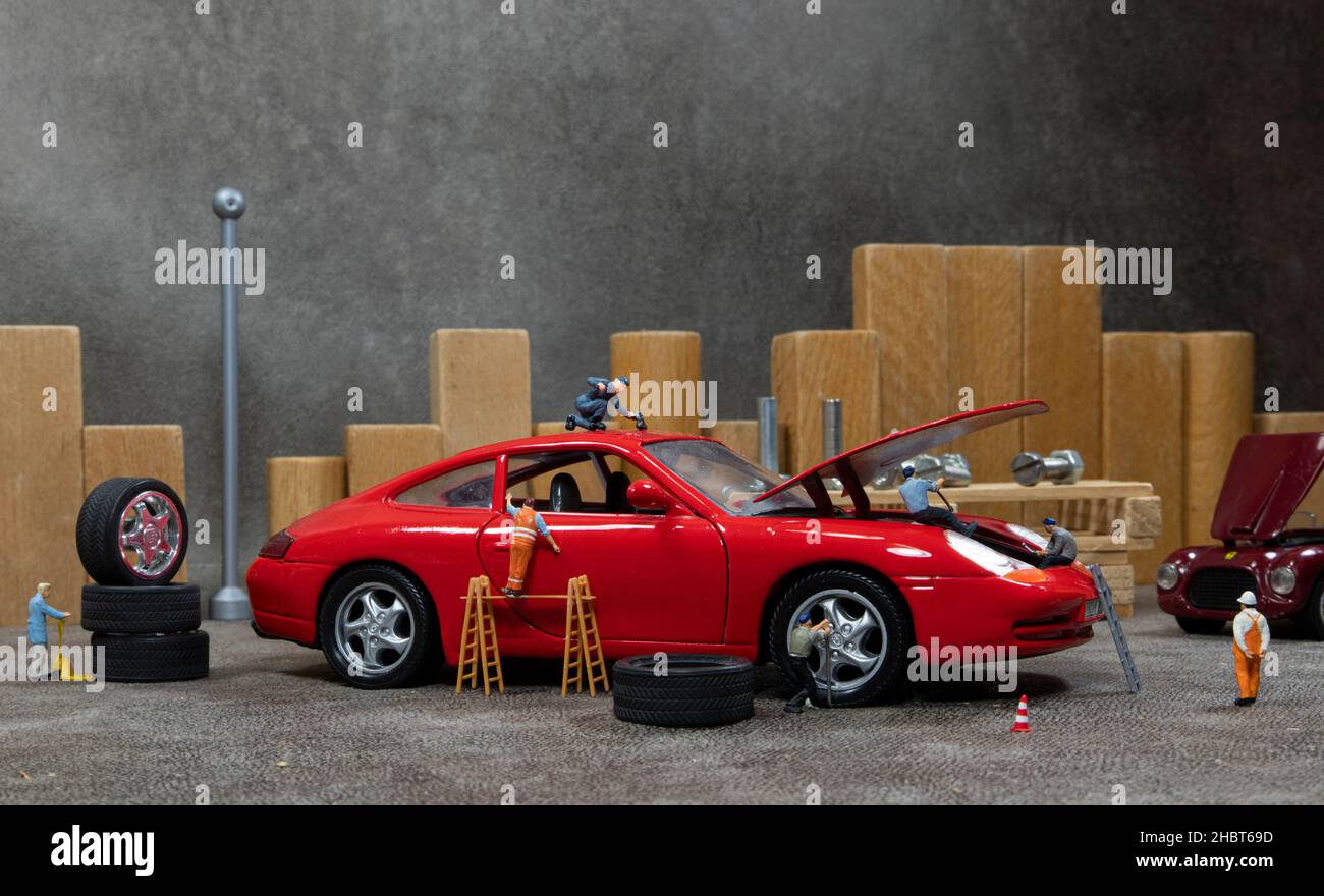 Little World Auto Garage Mann beschäftigt mit Reparatur Autos Stockfoto