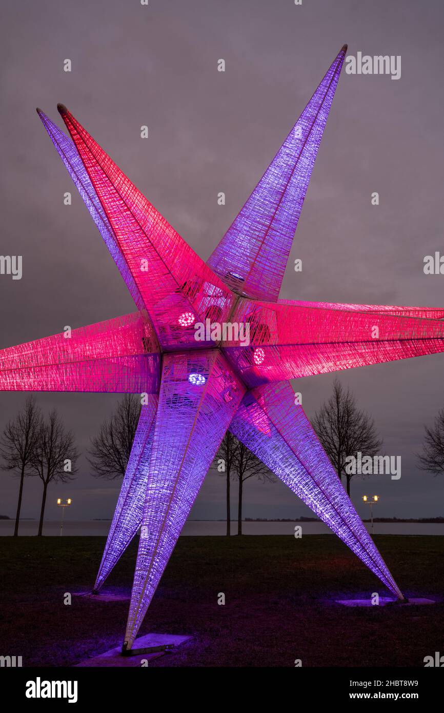 Stralsund, Deutschland. 21st Dez 2021. Auf einer Wiese an der Sundpromenade steht eine etwa sieben Meter hohe Weihnachtssterne. Quelle: Stefan Sauer/dpa/Alamy Live News Stockfoto