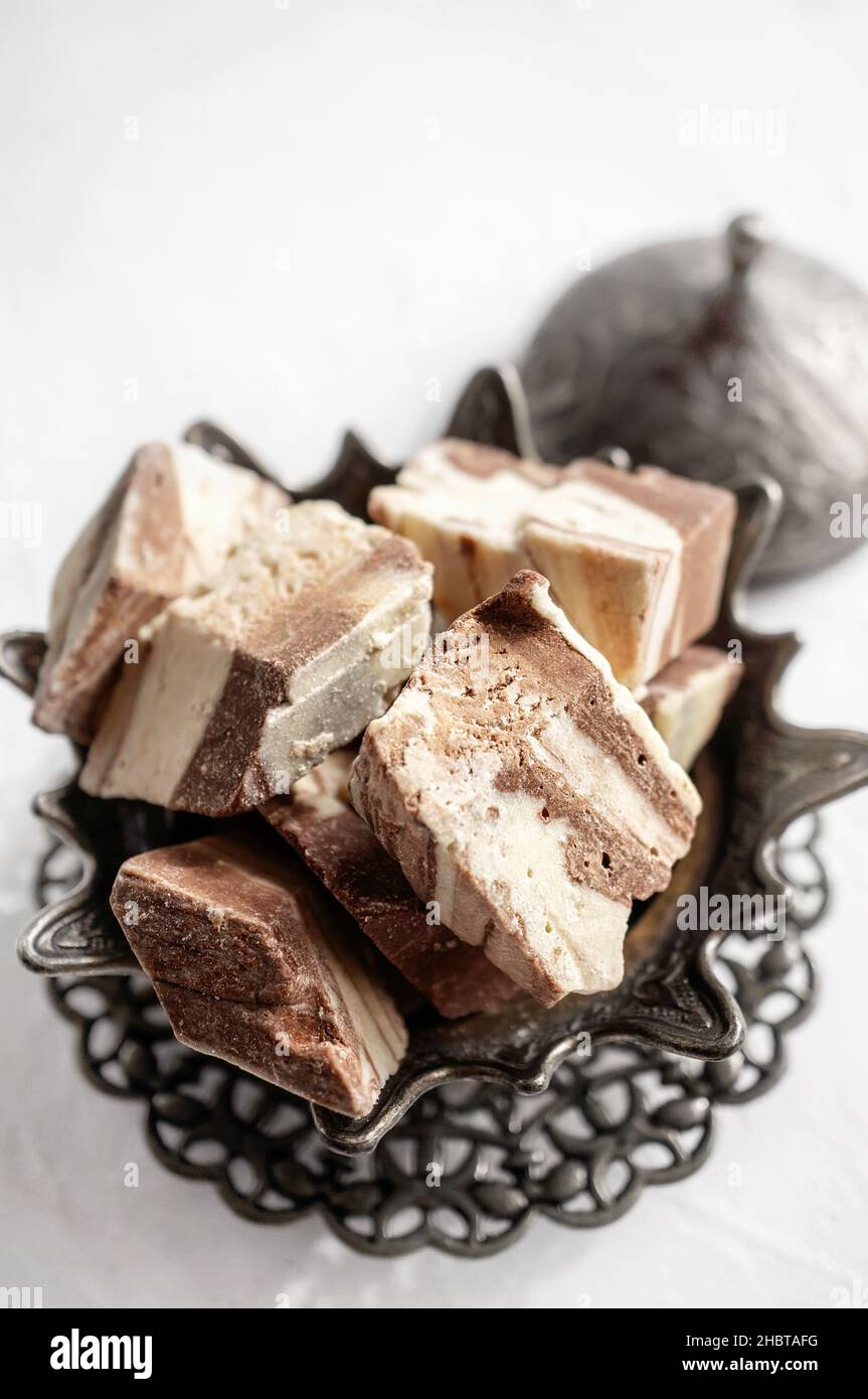 Teller mit Halva aus Sonnenblumenkernen auf einer Bronzeschale, selektiver Fokus. Stillleben mit Halva im arabischen Stil. Stockfoto