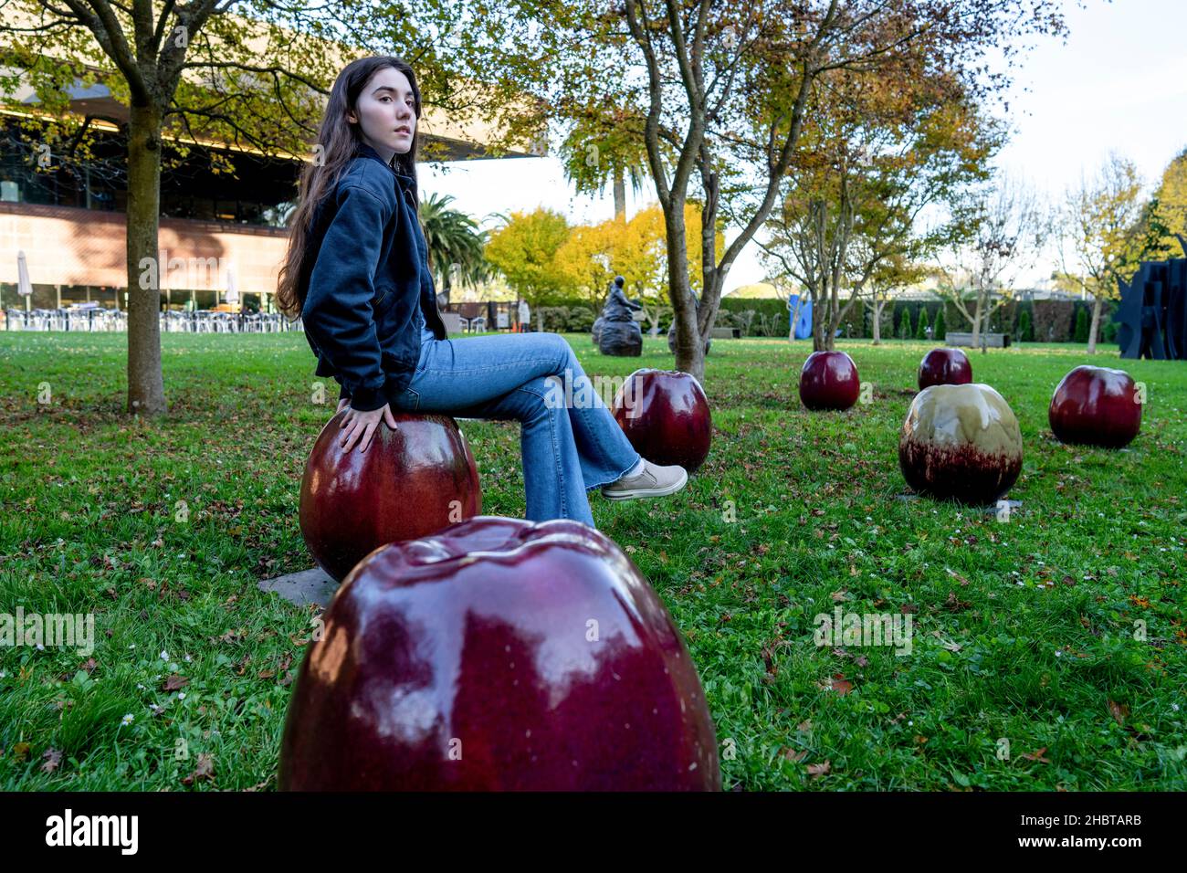 Eine Teenager-Frau saß auf großen Äpfeln Stockfoto