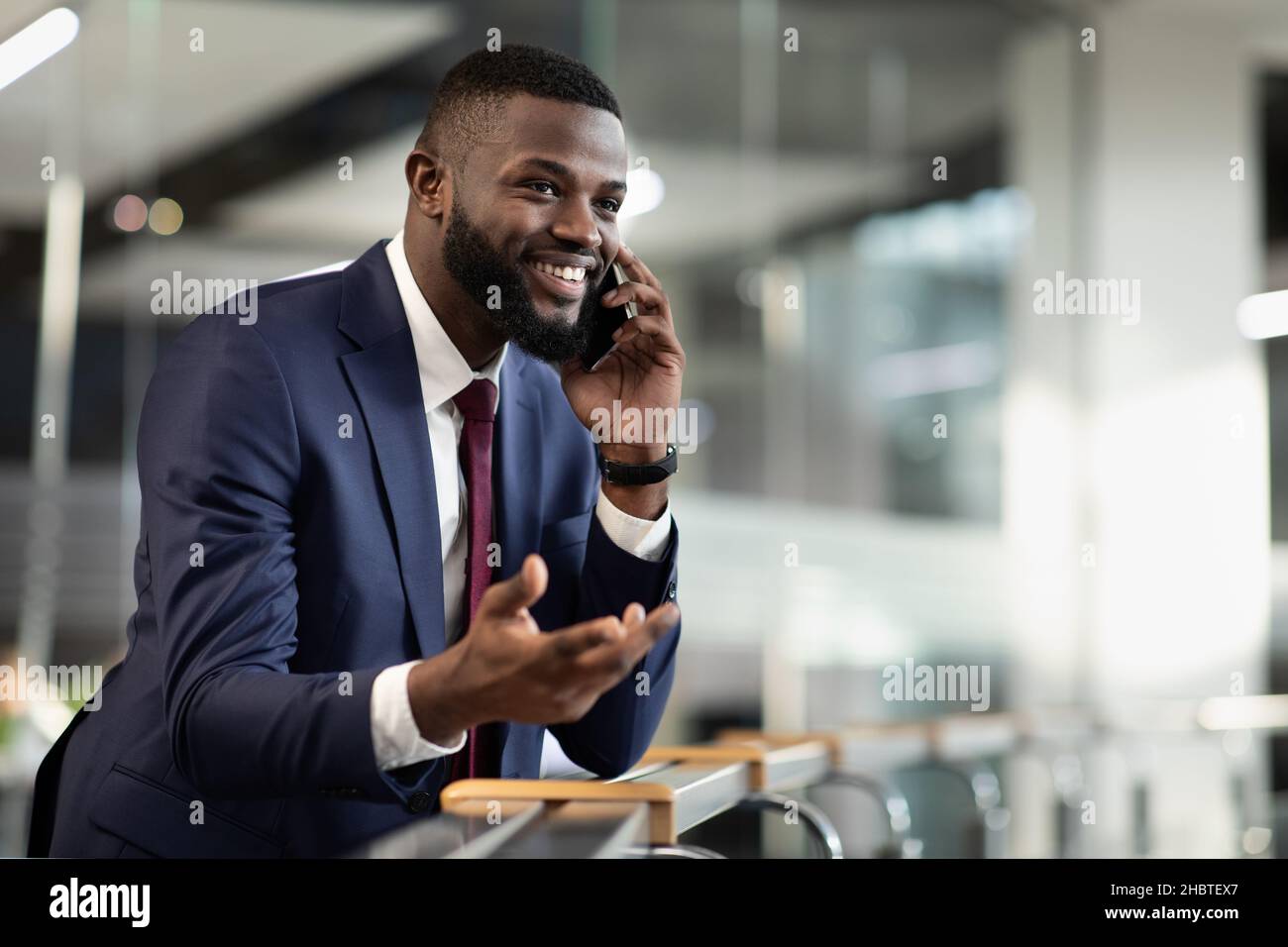 Wohlhabender afroamerikanischer Unternehmer, der Telefongespräche führt Stockfoto