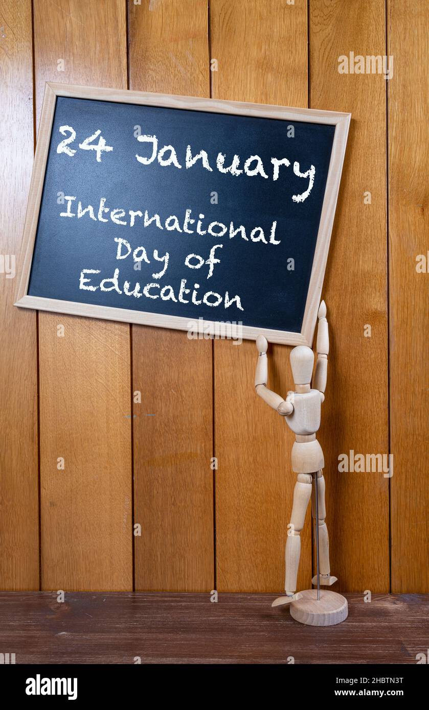 Eine hölzerne Schaufensterpuppe, die eine Tafel hält, um den internationalen Tag der Bildung am 25. Januar zu feiern Stockfoto