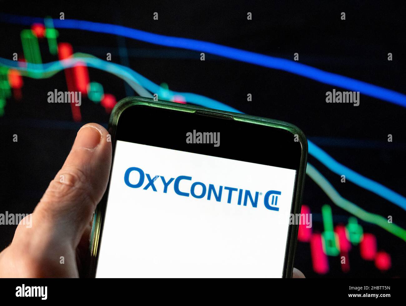 China. 09th Dez 2021. In dieser Abbildung wurde das Schmerzmittel OxyContin vom Pharmaunternehmen der Familie Sackler hergestellt, das die Schuld für die Opioidkrise der Vereinigten Staaten, Purdue Pharma, trägt. Das Logo wurde auf einem Smartphone mit einem Index der wirtschaftlichen Börse im Hintergrund angezeigt. Kredit: SOPA Images Limited/Alamy Live Nachrichten Stockfoto