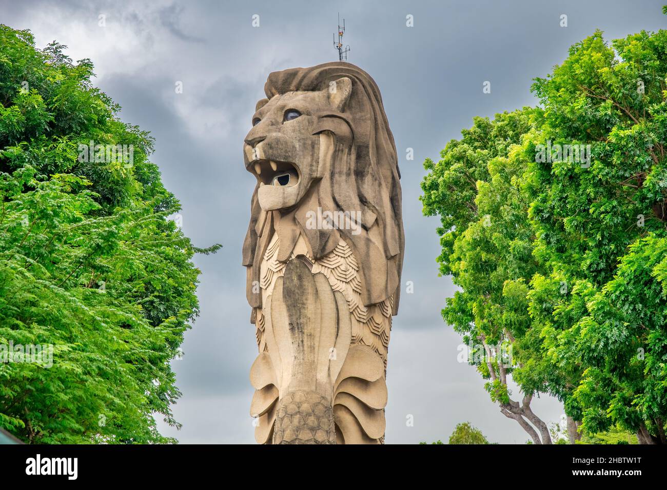 Singapur Merlion umgeben von Bäumen. Der Löwe ist ein Stadtsymbol Stockfoto