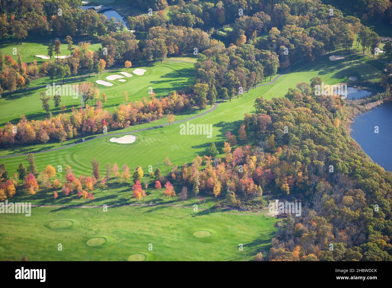 Luftaufnahme des Golfplatzes und des blauen Sees im Herbst Stockfoto