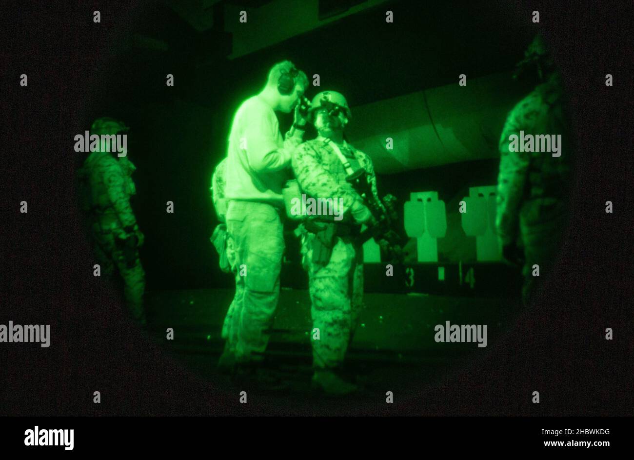British Royal Marine Cpl. Michael Dowd, links, ein Team der gepanzerten Unterstützungsgruppe mit der 43 Commando Fleet Protection Group Royal Marines, evaluiert die Stabsabteilung des US-Marine Corps. Dallas Bush, rechts, ein Kampfinstruktor und CQB-Instruktor (Nahkampf) mit dem Marine Corps Security Force Regiment, Genauigkeit des Eingriffs bei schwachem Licht während der Übung Tartan Eagle Phase II, Northumbria Police Range, Wallsend, England, 12. Dezember, 2021. Der Bereich erlaubte es den britischen Royal Marine CQB-Instruktoren, verschiedene Schießtechniken an die US-Marineinfanteristen einzuführen und ihre Fähigkeiten in feindlichem Engagement mit begrenztem l zu testen Stockfoto
