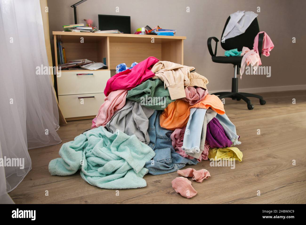 Stapel von achtlos verstreut Kleidung auf dem Boden. Stockfoto