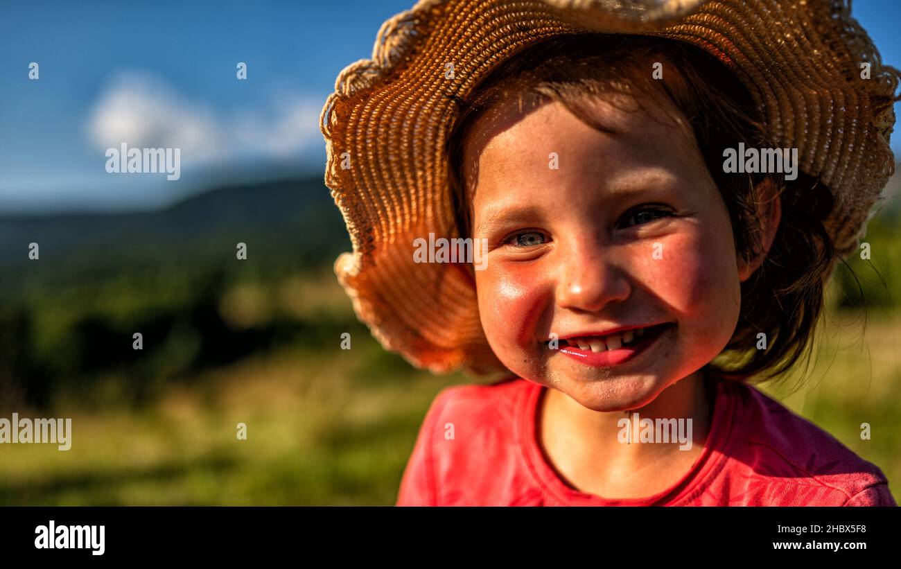 Ein junges Mädchen, das in den Bergen lächelt. Stockfoto