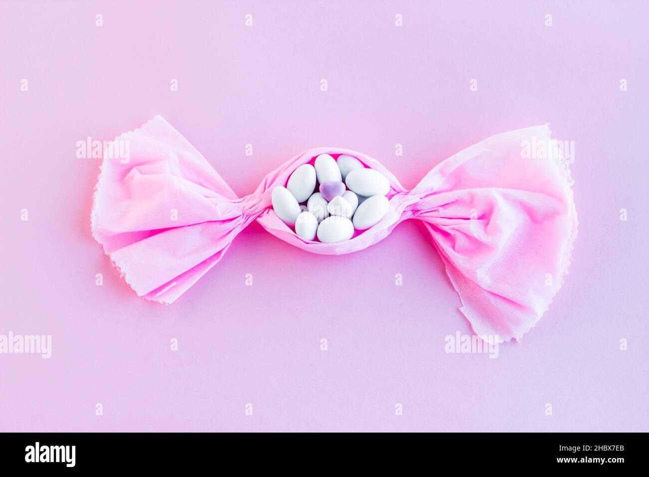 Köstliche weiße Farbe Mandel Süßigkeiten in Bonbon Süßigkeiten auf rosa  Hintergrund mit Copy Space geformt.Draufsicht Stockfotografie - Alamy