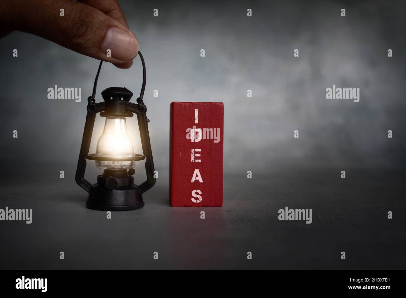 Auf der Suche nach Ideen Konzept. Hand hält Vintage-Gaslampe und Holzfliesen mit Text-IDEEN Stockfoto