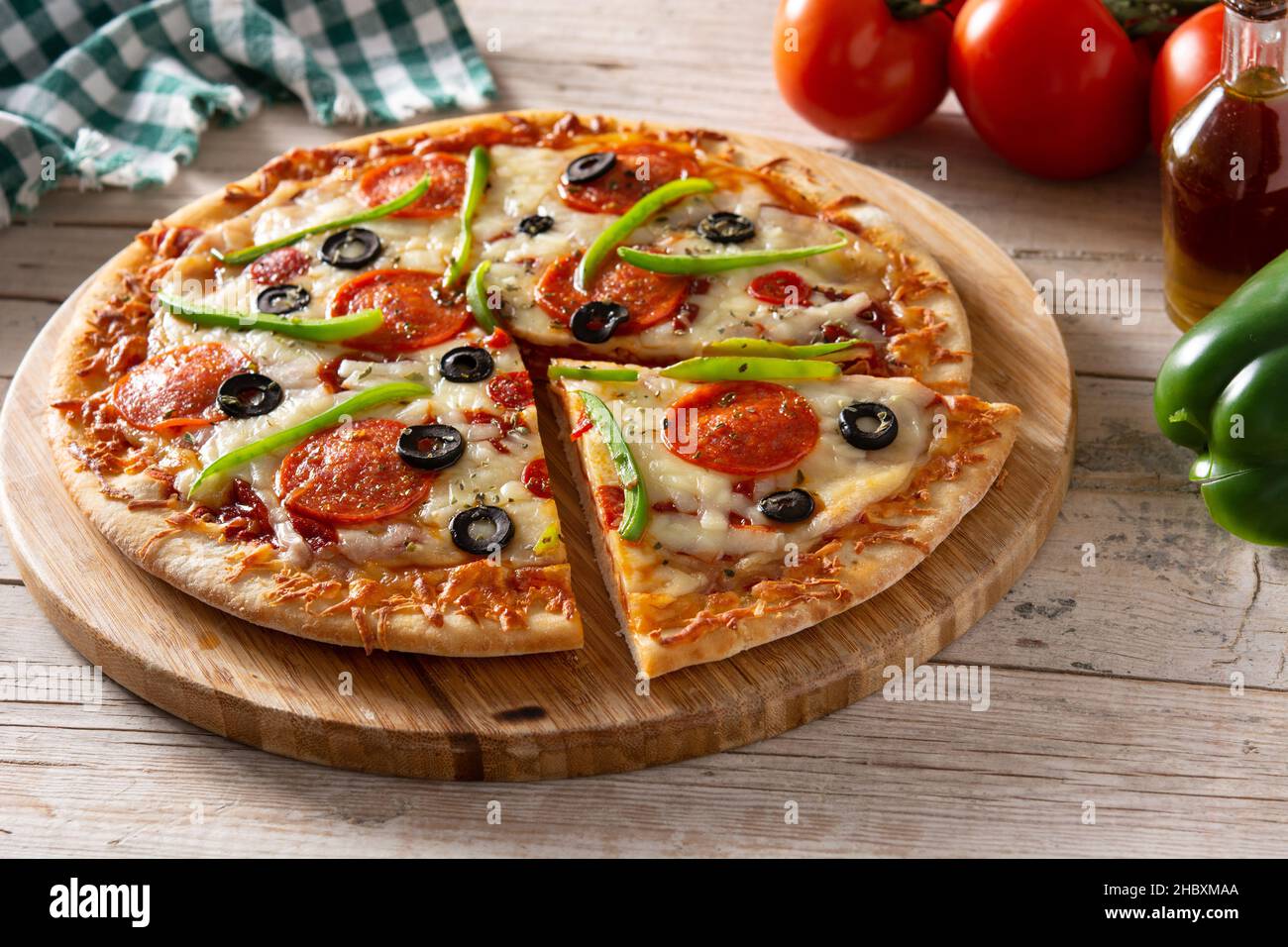 Traditionelle, erstklassige Pizza auf einem rustikalen Holztisch Stockfoto