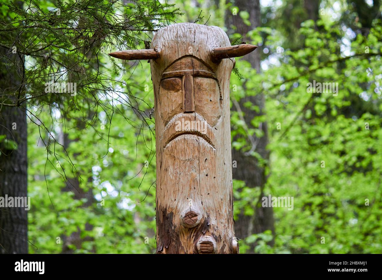 Das Bild der slawischen Gottheit Veles, das aus einem Baumstamm auf einem neo-heidnischen Tempel im Wald geschnitzt wurde. Kaluzhskiy Region, Russland. Veles - der gott des Viehs Stockfoto