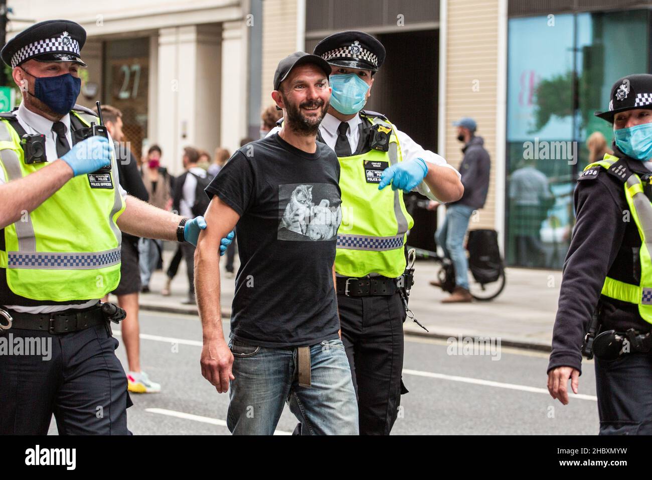 Polizei verhaftete lächelnden Protestanten der Tieraufstand mit Kätzchen-T-Shirt London 2020 Stockfoto
