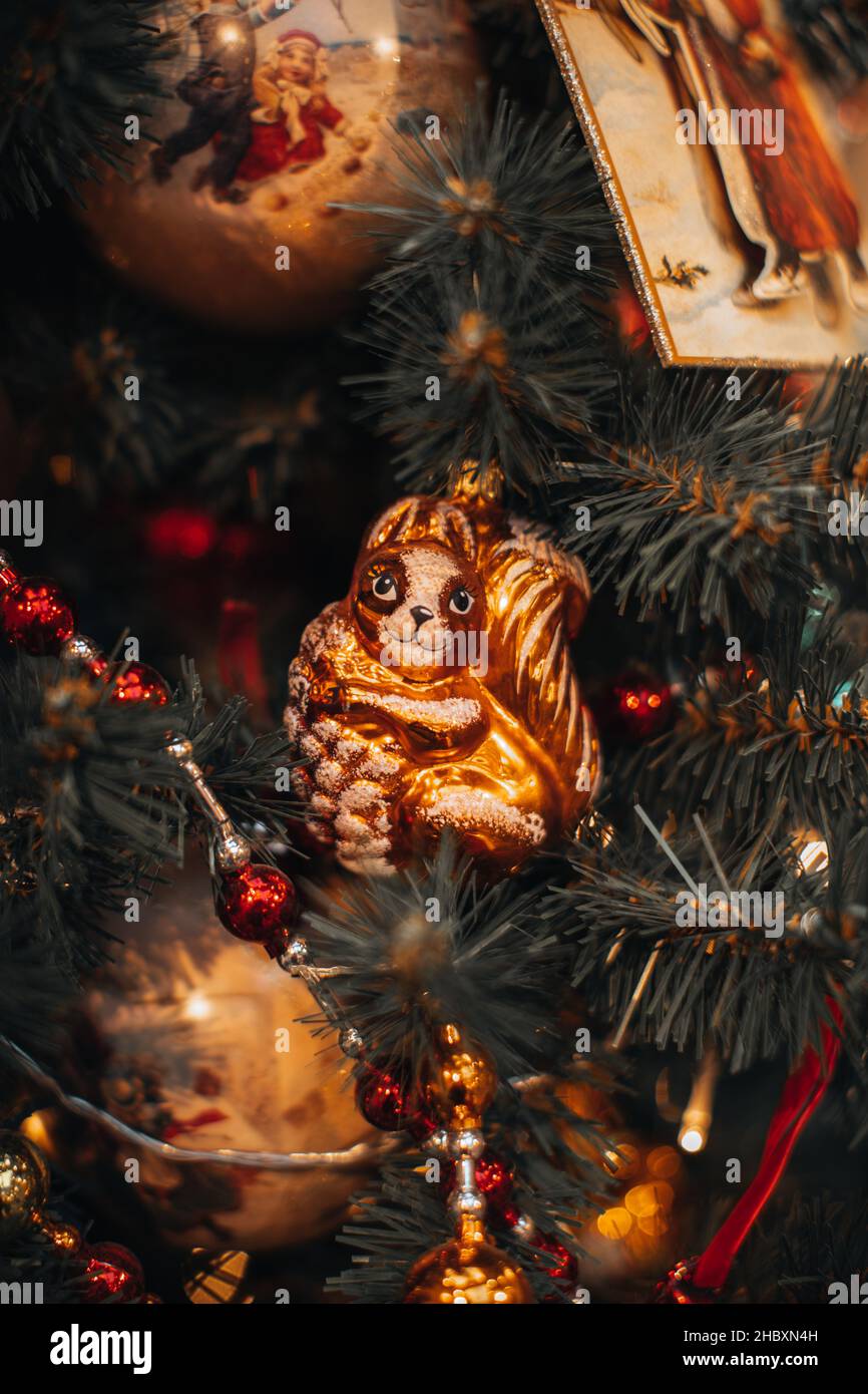 Vintage Weihnachten Spielzeug Figur von lustigen Eichhörnchen hängen auf den Weihnachtsbaum Äste mit roten Perlen. Festliche Zauberdetails für das neue Jahr Stockfoto