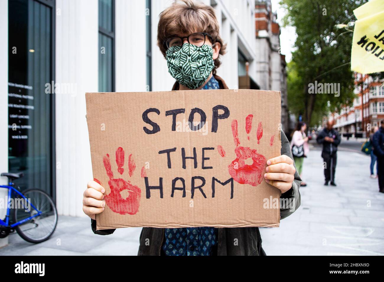 Klimaprotesten mit handgeschriebenem Schild mit der Aufschrift Stop the Harm, London 2022 Stockfoto