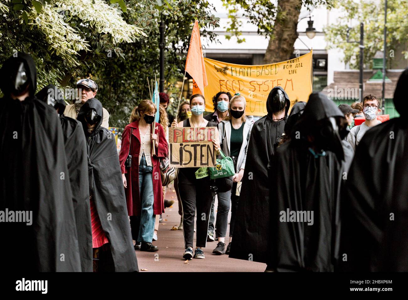 Tieraufstandsprotestierende, die als Pestärzte gekleidet sind, mit einem Bitte-Anhörplakette London 2020 Stockfoto