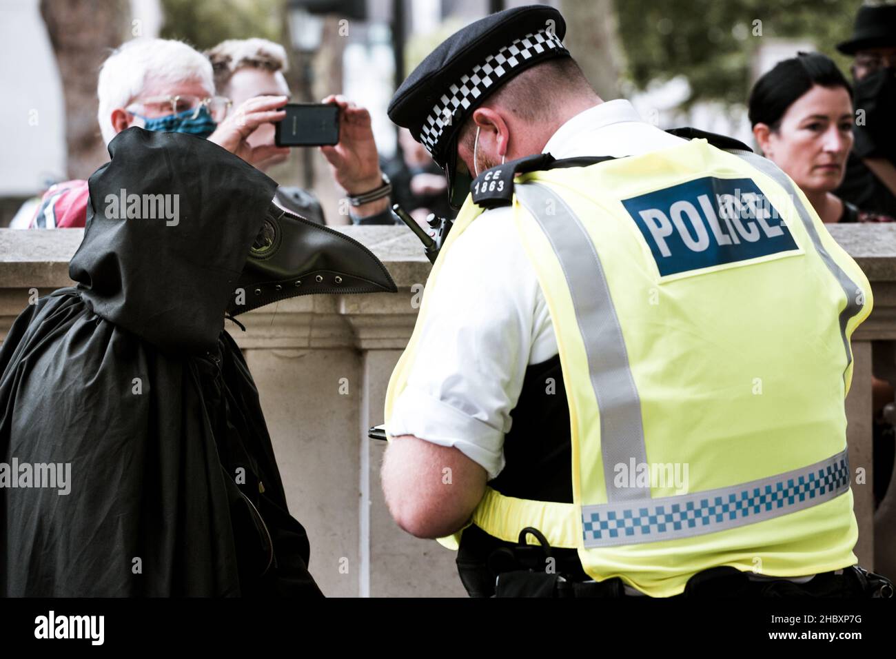 Die Polizei durchsucht Tieraufständler, der als Pestarzt gekleidet ist, in der Nähe der Downing Street London 2020 Stockfoto