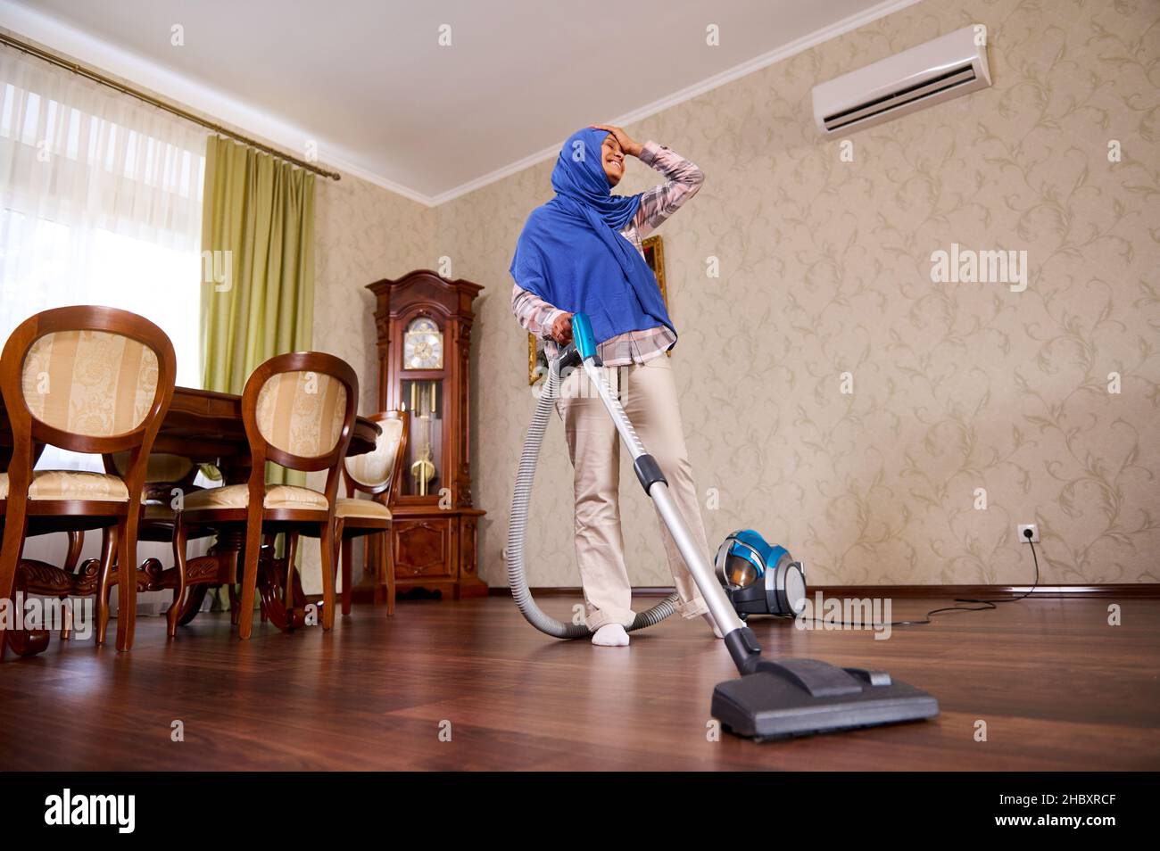 Entzückende, glückliche arabische muslimische junge Frau oder Hausfrau mit  Staubsauger, die zu Hause den Boden saugt, tanzt, singt, genießt das  Aufräumen. Househol Stockfotografie - Alamy