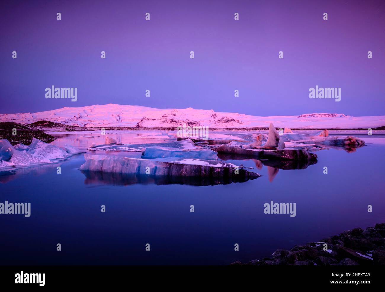 Eisschollen in Island in rosa Licht in der Dämmerung. Stockfoto
