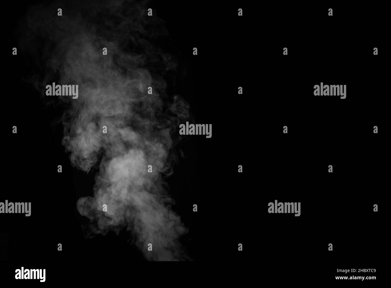 Fragment von weißem, heißem, lockigen Dampfrauch, isoliert auf schwarzem Hintergrund, Nahaufnahme. Erstellen Sie mystische Fotos. Abstrakter Hintergrund, Designelement Stockfoto