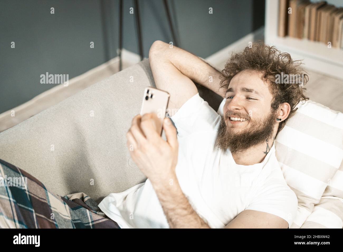 Nice Blogger Boy hat eine Live-Übertragung an seine Anhänger von seinem Profil durch sein Smartphone. Cute Boy Erhöht Die Emotionale Bindung Seiner Seite. Nahaufnahme. Hochwertige Fotos Stockfoto