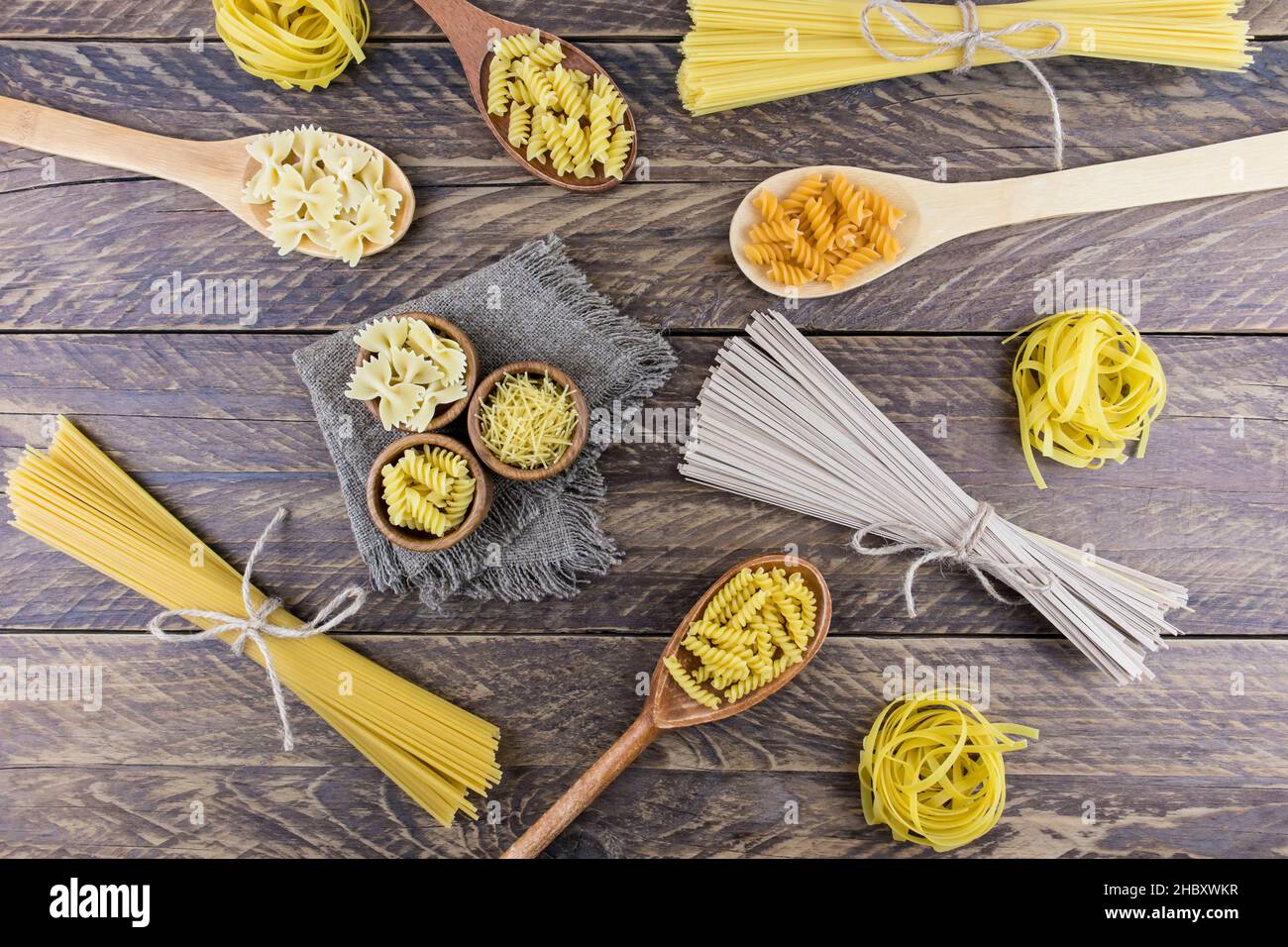 Eine Vielzahl von Arten und Formen von getrockneten Nudeln auf einem hölzernen Dorftisch. Paste Hintergrund. Blick von oben Stockfoto