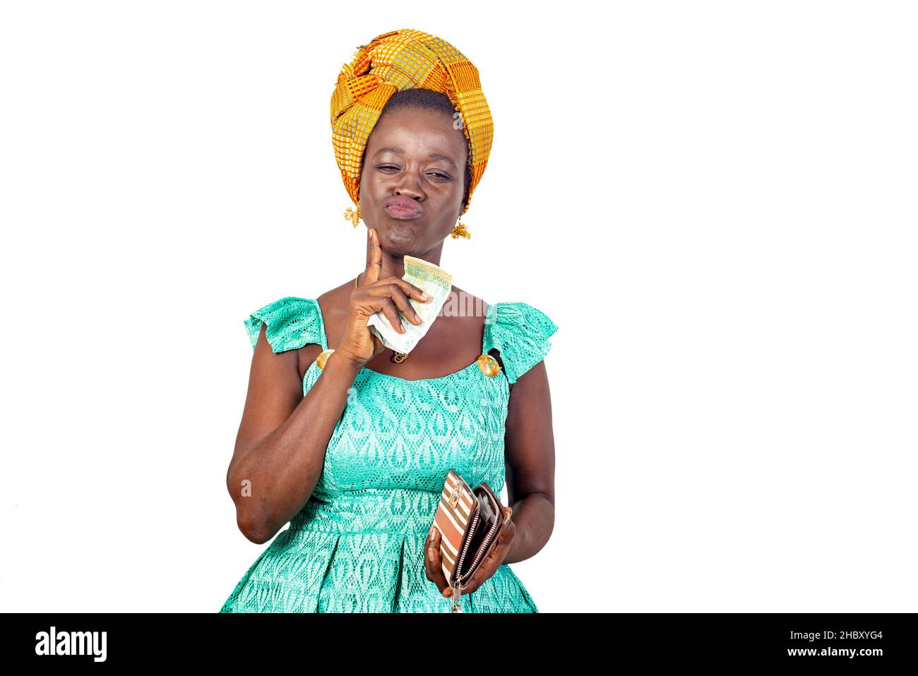 Schöne junge Frau in traditionellem Outfit und denkt darüber nach, was sie mit ihrem Geld in der Hand kaufen sollte. Stockfoto