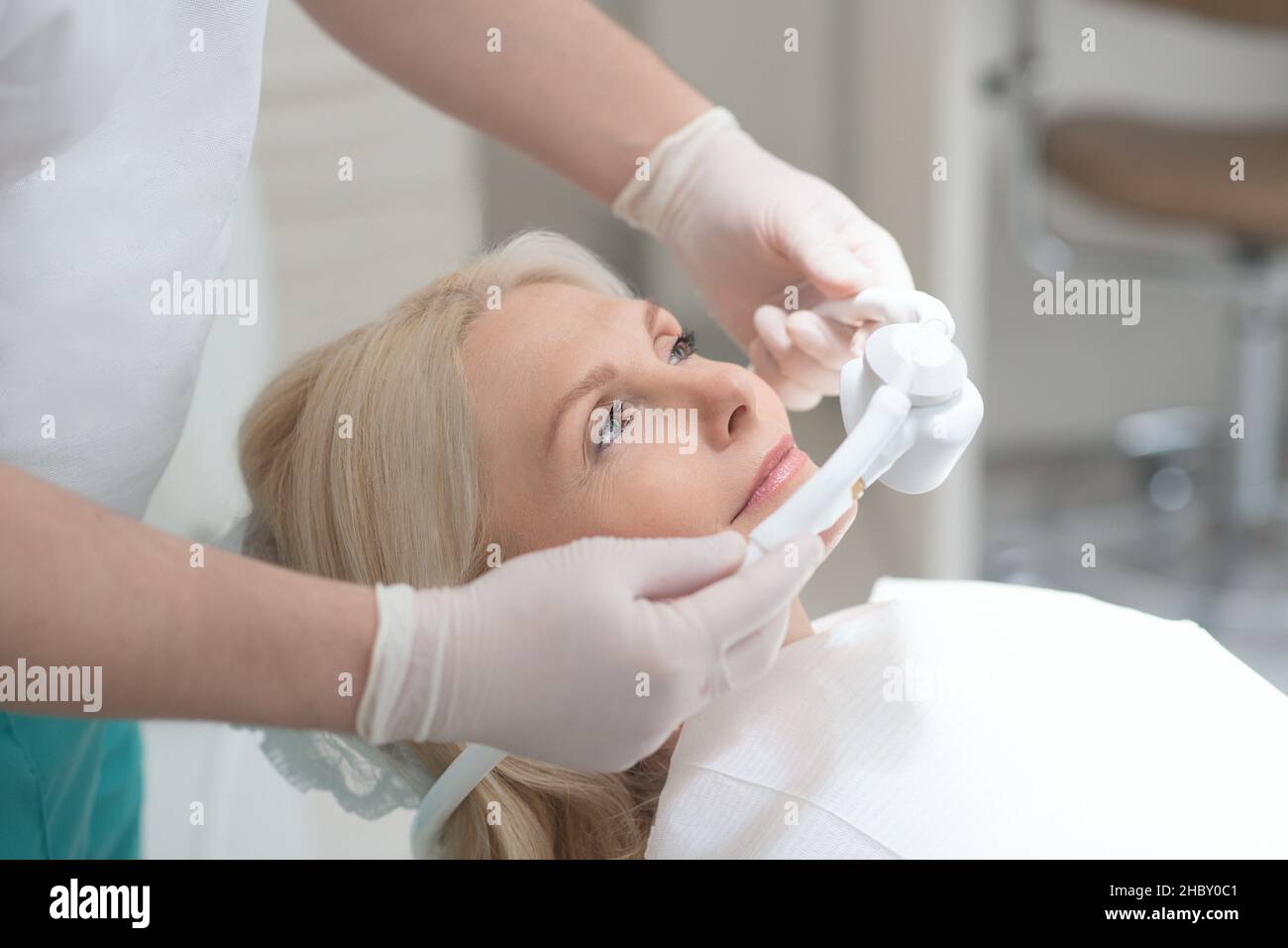 Ein Zahnarzt, der seinen Patienten für die Zahnoperation vorbereitet Stockfoto
