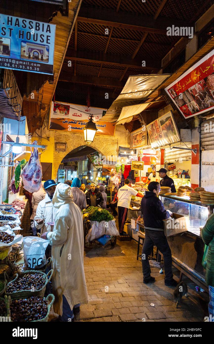 Eine schmale Straße mit Marktständen und Geschäften in den Souks in der Medina, Fes, Marokko Stockfoto