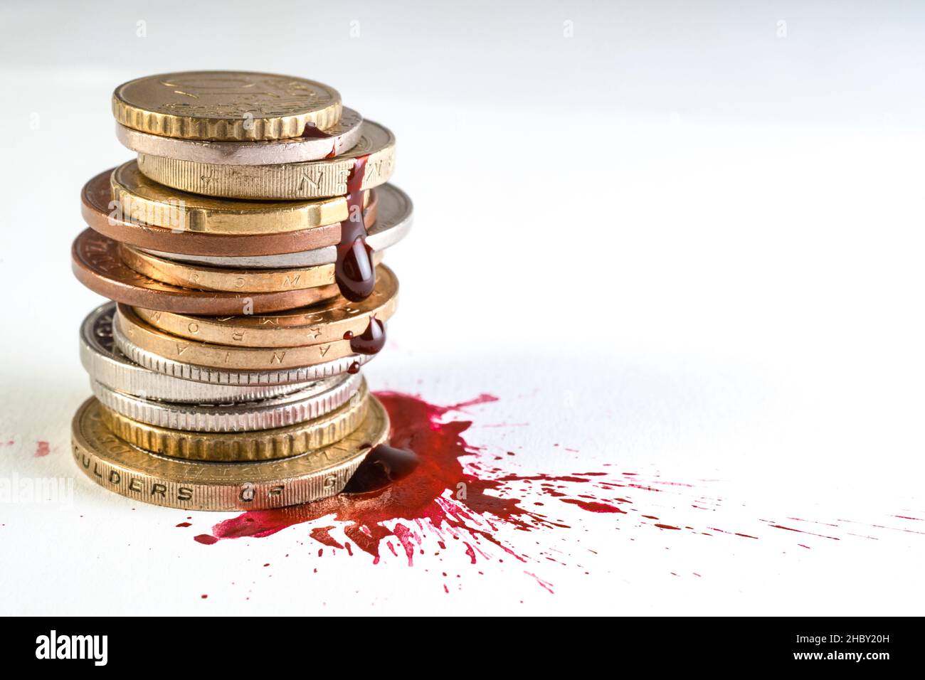 Bluttropfen, Spuren und Spritzer, mit einem Stapel von Münzen isoliert auf weißen, selektiven Fokus Makro, Kriminalität Geld Konzept Stockfoto